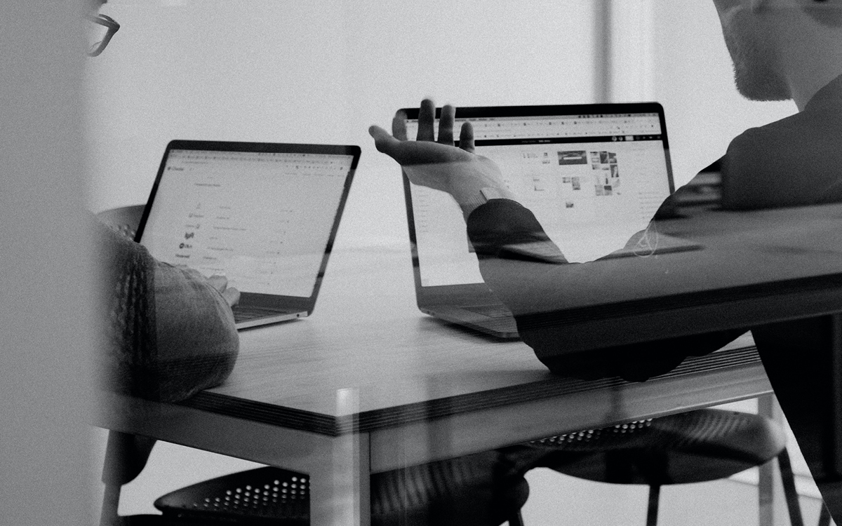 people talking to each other while working on their laptops